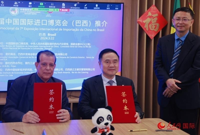 巴西外貿(mào)商會(huì)聯(lián)合會(huì)會(huì)長(zhǎng)阿代爾·羅伯托（左）與中國(guó)國(guó)際進(jìn)口博覽局副局長(zhǎng)吳政平（中）現(xiàn)場(chǎng)簽訂協(xié)議。人民網(wǎng)記者 宋亦然攝