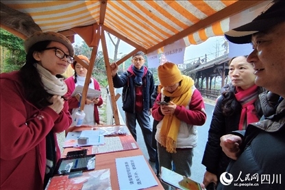 1月6日，“2024成都蒲江柑甜采摘節(jié)”上，記者見到了小萌（左一）和許多年輕人忙著做訪客接待、現(xiàn)場布置、票務(wù)核對、采摘服務(wù)等工作。人民網(wǎng)記者朱虹攝