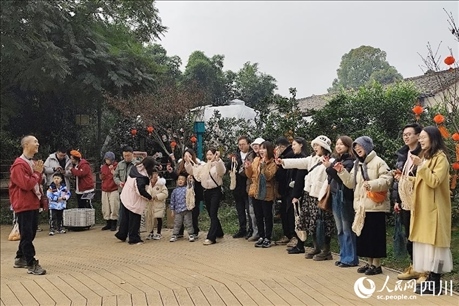 葉科（左一）給前來參與活動的“柑爸柑媽”介紹生態(tài)種植果。人民網(wǎng)記者朱虹攝