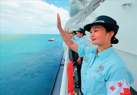 中國海軍“和平方舟”號醫(yī)院船結束訪問湯加時，任務官兵中的文職人員向歡送人群揮手告別（2023年8月4日攝）。徐巍攝/本刊