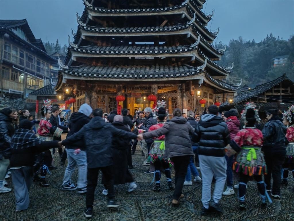 法國青年與當(dāng)?shù)卮迕駹渴痔?。新華社記者 羅羽 攝