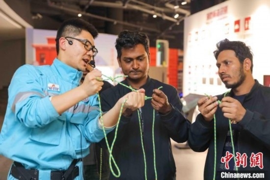 5月9日，工作人員指導(dǎo)留學(xué)生學(xué)習(xí)打繩結(jié)。張鷹 攝