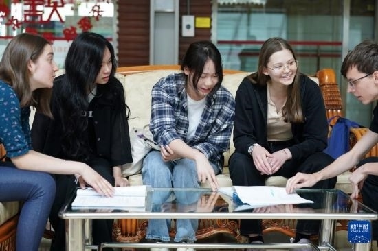 4月28日，宋智孝（右二）和胡靈月（左一）在北京首都師范大學(xué)校園內(nèi)與同學(xué)交流。新華社記者 彭子洋 攝