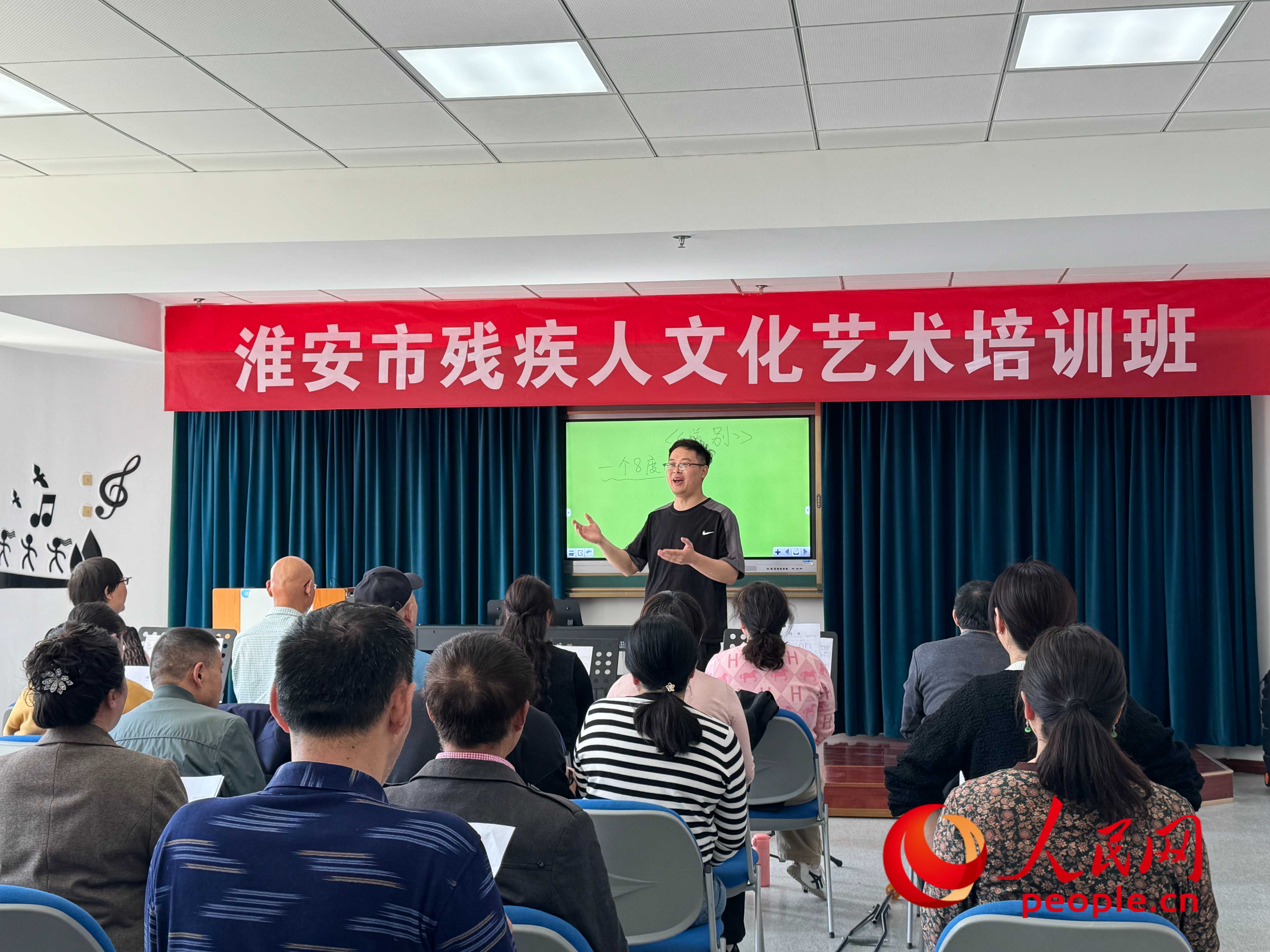 在淮安市殘疾人文化藝術(shù)培訓(xùn)班上，聲樂老師在教殘疾人唱《送別》這首歌曲。人民網(wǎng) 周靜圓攝