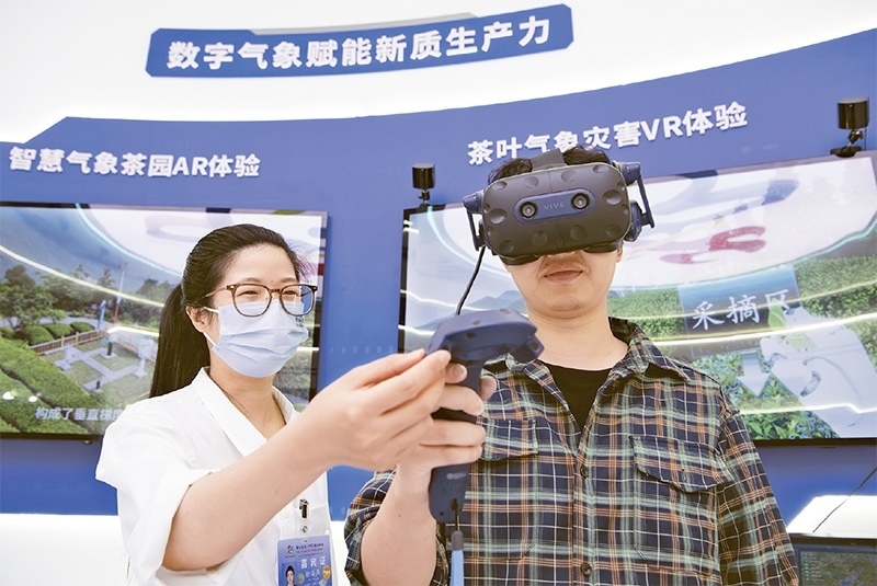 2024年5月23日，第七屆數(shù)字中國建設(shè)峰會現(xiàn)場體驗區(qū)在福州海峽國際會展中心向?qū)I(yè)觀眾開放。本次現(xiàn)場體驗區(qū)圍繞本屆峰會主題“釋放數(shù)據(jù)要素價值，發(fā)展新質(zhì)生產(chǎn)力”，設(shè)置“數(shù)字惠民”、“數(shù)字能力”、“數(shù)字基礎(chǔ)”、“數(shù)字生態(tài)”、“數(shù)字賦能”五大板塊。圖為一名觀眾（右）在數(shù)字氣象賦能新質(zhì)生產(chǎn)力展臺上進行體驗。 新華社記者 魏培全/攝