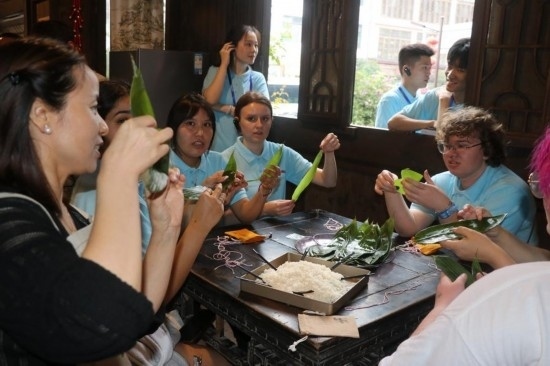 6月9日，美國(guó)青年代表在重慶永川松溉古鎮(zhèn)體驗(yàn)包粽子。新華社記者 周思宇 攝