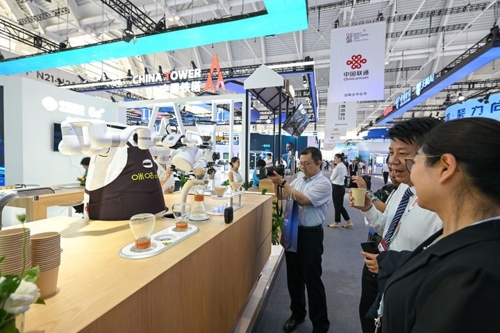 6月20日，與會(huì)者品嘗機(jī)器人沖調(diào)出的咖啡。新華社記者 孫凡越 攝