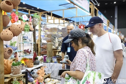 游客在蘭納博覽會(huì)特色展位上選購(gòu)工藝品。人民網(wǎng)記者楊一攝