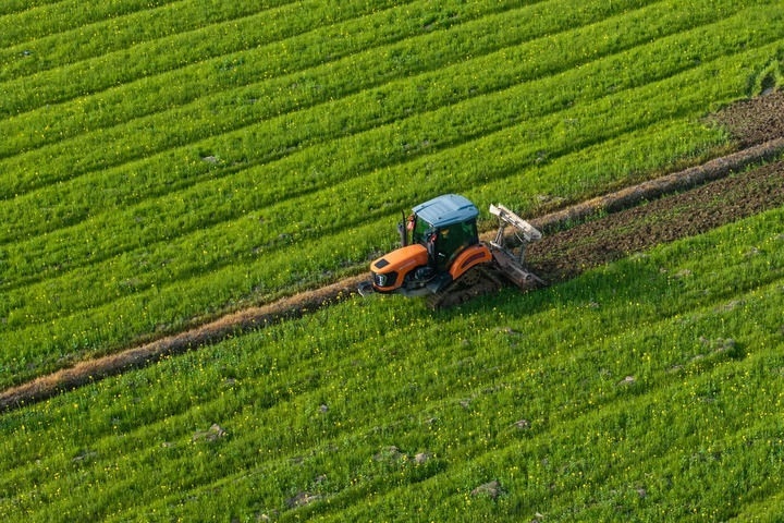 2024年3月19日，在湖南省常德市鼎城區(qū)謝家鋪鎮(zhèn)港中坪村，村民駕駛農(nóng)機(jī)翻耕田地（無(wú)人機(jī)照片）。新華社記者 陳思汗 攝