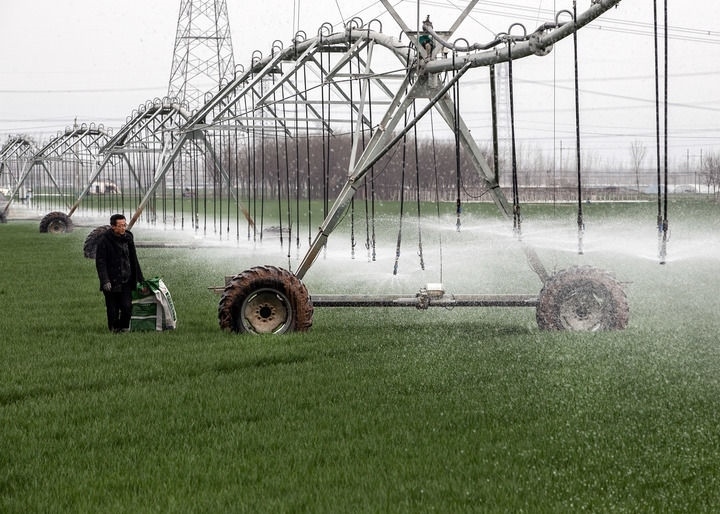2024年3月18日，在河南省焦作市博愛(ài)縣孝敬鎮(zhèn)東原莊村瑞輝家庭農(nóng)場(chǎng)，村民使用全自動(dòng)指針式噴灌機(jī)進(jìn)行澆灌作業(yè)。新華社發(fā)（程全攝）