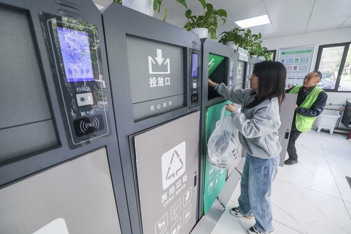 2024年4月10日，在浙江省湖州市吳興區(qū)飛英街道新華府小區(qū)內(nèi)，居民在垃圾分類智能系統(tǒng)的指導(dǎo)下進(jìn)行垃圾分類投放，居民的投放情況將實(shí)時(shí)匯總到智慧服務(wù)平臺(tái)，會(huì)有相應(yīng)的積分獎(jiǎng)勵(lì)。新華社記者 徐昱 攝