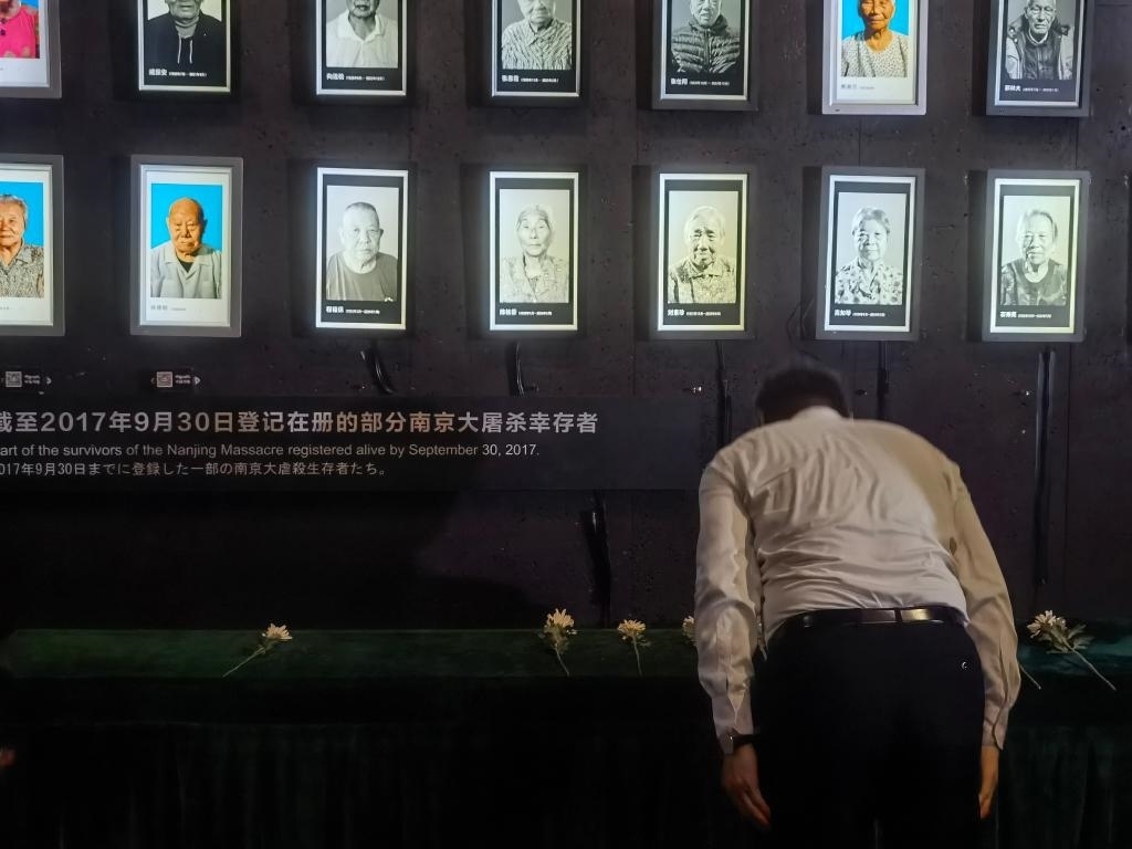7月18日，人們向離世的南京大屠殺幸存者獻(xiàn)花、鞠躬。新華社記者邱冰清 攝