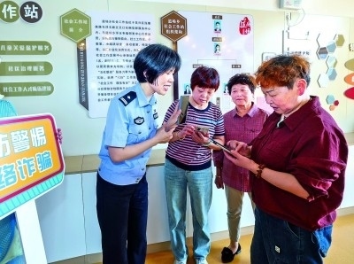 浙江湖州民警指導(dǎo)居民加入湖州“e企安”微信群，實(shí)時(shí)接收反詐信息。新華社發(fā)