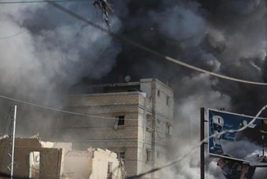 7月21日，在加沙地帶中部的努賽賴(lài)特難民營(yíng)，遭以軍空襲的建筑冒出滾滾濃煙。新華社發(fā)（馬爾萬(wàn)·達(dá)烏德攝）