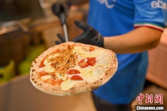 近日，韋榮耀展示他制作的“老友味”披薩。 俞靖 攝
