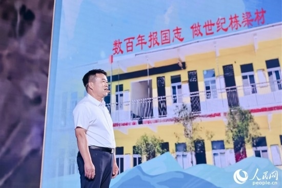 張玉滾分享用一根扁擔(dān)送孩子們走出大山的故事。人民網(wǎng)攝