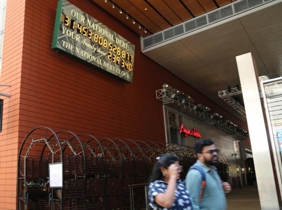 2023年5月29日，人們經(jīng)過美國(guó)紐約曼哈頓的“國(guó)債鐘”。“國(guó)債鐘”是一個(gè)大型計(jì)數(shù)器，它實(shí)時(shí)更新美國(guó)的公共債務(wù)總額，并顯示出每個(gè)美國(guó)家庭所要負(fù)擔(dān)的數(shù)額。 新華社記者劉亞南攝