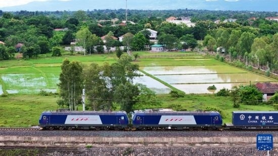 8月5日，由老撾籍火車司機(jī)獨(dú)立駕駛的滿載貨物的列車駛出萬象站，向中國昆明進(jìn)發(fā)（無人機(jī)照片）。新華社發(fā)（楊永全 攝）
