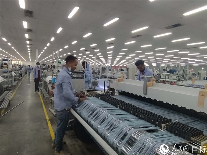 無(wú)錫金茂埃塞面料廠車間內(nèi)，當(dāng)?shù)毓と苏谝唤z不茍地作業(yè)。人民網(wǎng)記者 黃培昭攝