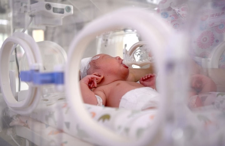 2024年6月1日，在西安國(guó)際醫(yī)學(xué)中心醫(yī)院新生兒科病房，護(hù)士為新生兒喂奶。 新華社記者 劉瀟 攝