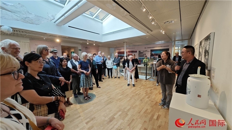 參展人、景德鎮(zhèn)陶瓷大學(xué)美術(shù)學(xué)院副院長(zhǎng)邵長(zhǎng)宗（右一）向來(lái)賓介紹參展作品。人民網(wǎng)記者 殷淼攝