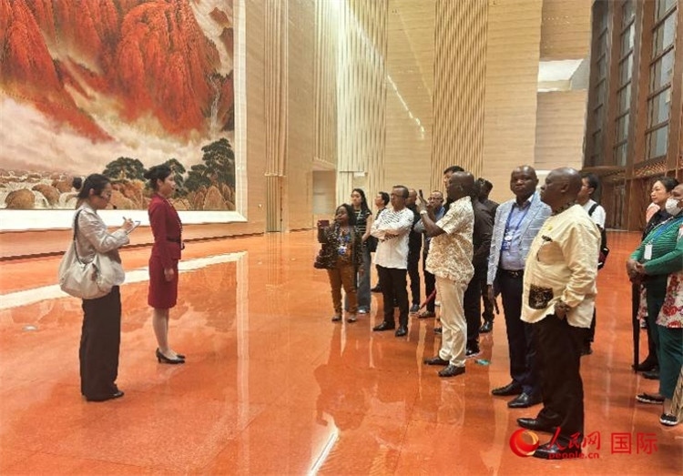 代表團(tuán)在入口處聽取講解。人民網(wǎng) 曹欣悅攝