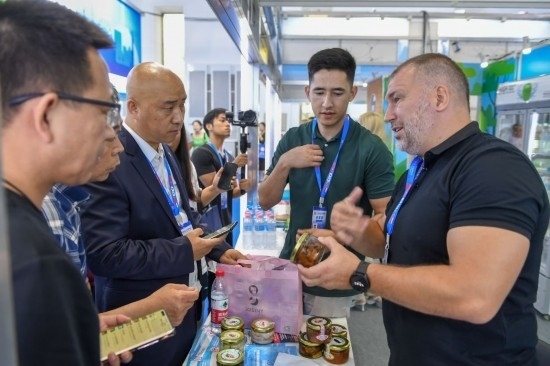 2023年8月23日，在第十四屆中國(guó)—東北亞博覽會(huì)東北亞商品館，俄羅斯參展商向參觀者介紹商品。