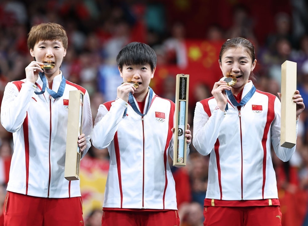 冠軍中國隊選手王曼昱、孫穎莎、陳夢（從左至右）在巴黎奧運會乒乓球女子團體頒獎儀式上（2024年8月10日攝）。新華社記者 王東震 攝