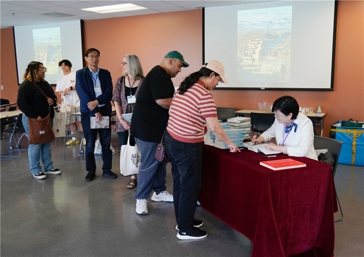 作者顧春芳在活動現(xiàn)場簽名贈書。羅先勇攝