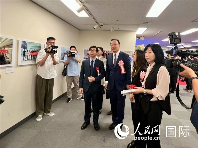 中國國際航空日韓地區(qū)支社支社長馮力為中國駐日本大使館臨時代辦施泳等嘉賓介紹展出圖片。人民網(wǎng) 許可攝