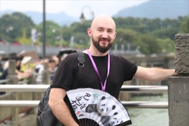 俄羅斯塔斯社執(zhí)行編輯葉夫根尼·扎多羅日內在都江堰魚嘴拍照留念。（李佩藺 攝）