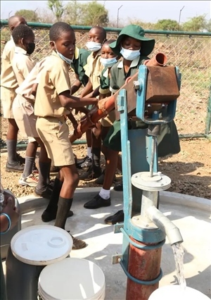 △2021年11月，在津巴布韋南馬塔貝萊蘭省省會(huì)關(guān)達(dá)的塞農(nóng)多小學(xué)，學(xué)生從中國(guó)援建水井里打水。