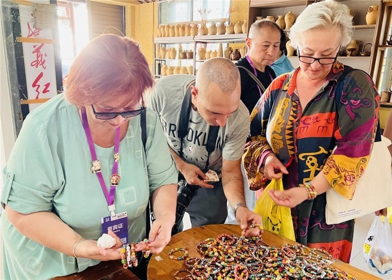 歐亞媒體考察團(tuán)成員在母氏陶藝館內(nèi)挑花了眼，色彩絢麗、質(zhì)地均勻的陶藝手串讓他們愛不釋手?！斑@里的東西都太實惠了！”塔吉克斯坦《索格特真理報》政論部主任娜塔利婭·多羅費耶娃說。花茂村的特色產(chǎn)品物美價廉，讓考察團(tuán)成員為家人好友買到了心儀的禮物，也為此次以四川成都為起點，路經(jīng)南充、廣安至貴州遵義的考察行程畫上了圓滿句號。（張亞欣攝）