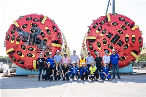 中外員工在盾構(gòu)機(jī)前合影。中國電建供圖