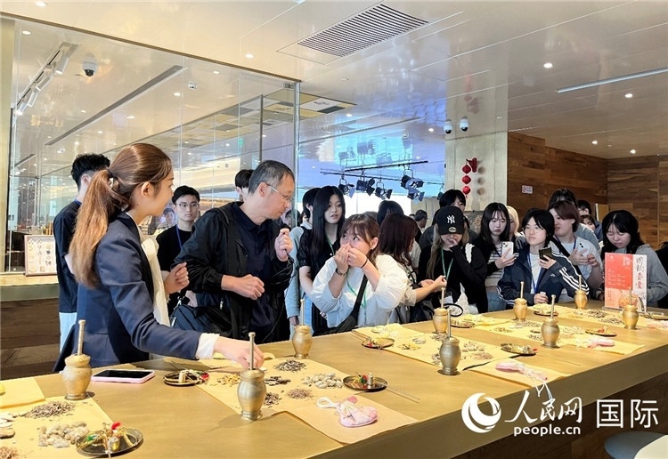 1. 日中友好協(xié)會青年代表團一行學習中醫(yī)香囊制作工序。（人民網(wǎng)記者陳思 攝）