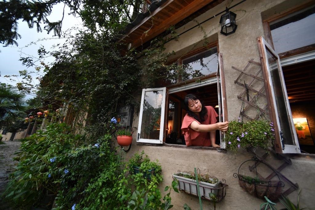 8月29日，在福建省屏南縣熙嶺鄉(xiāng)，龍?zhí)洞濉靶麓迕瘛泵泛暝诖蚶碜约航?jīng)營的民宿外墻裝飾花盆。新華社記者姜克紅 攝