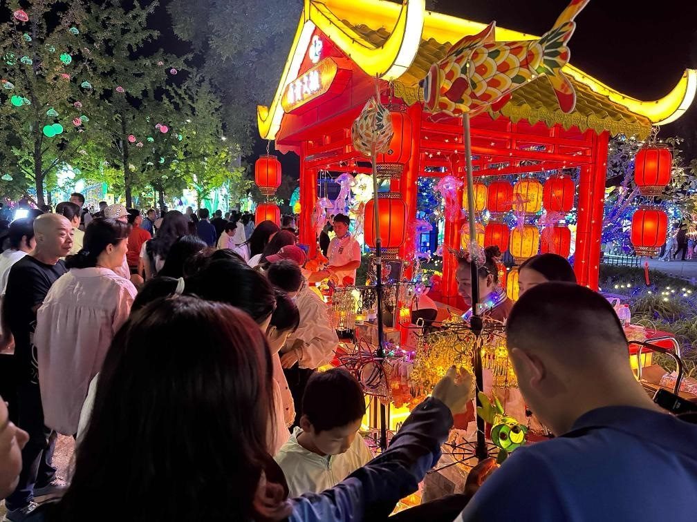 市民游客在2024年北京中秋國(guó)慶彩燈游園會(huì)上選購(gòu)特色文創(chuàng)商品。新華社記者楊淑君 攝