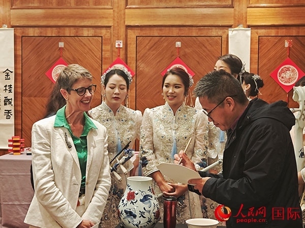 現(xiàn)場的非遺傳承人為英國觀眾展示畫技。人民網(wǎng)記者 邢雪攝