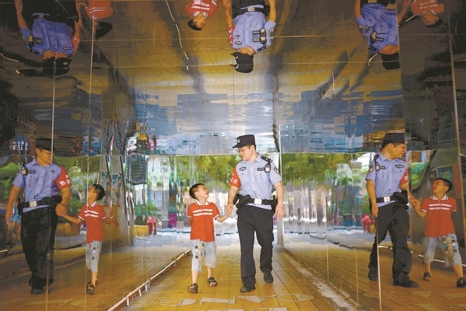 ?7月16日，重慶市公安局江北區(qū)分局一名民警在巡邏途中遇到一個獨自玩耍的小男孩，民警將其送回家。王洪平攝