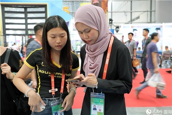東博會現(xiàn)場，馬來西亞展商在同中方工作人員交談。人民網(wǎng)記者 趙益普攝