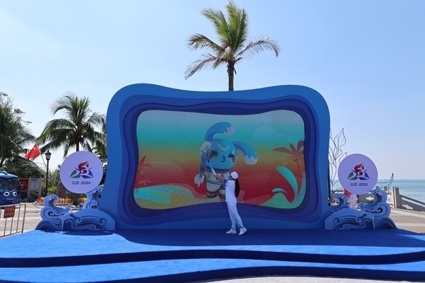 第12棒火炬手“點(diǎn)燃”現(xiàn)場大屏幕上運(yùn)動(dòng)會(huì)吉祥物“吉貝”手中的火炬。主辦方供圖