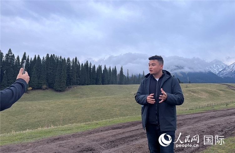 在庫爾德寧，吾買爾江被雪山美景震撼，即興錄制了短視頻作品。人民網(wǎng)記者曾書柔攝