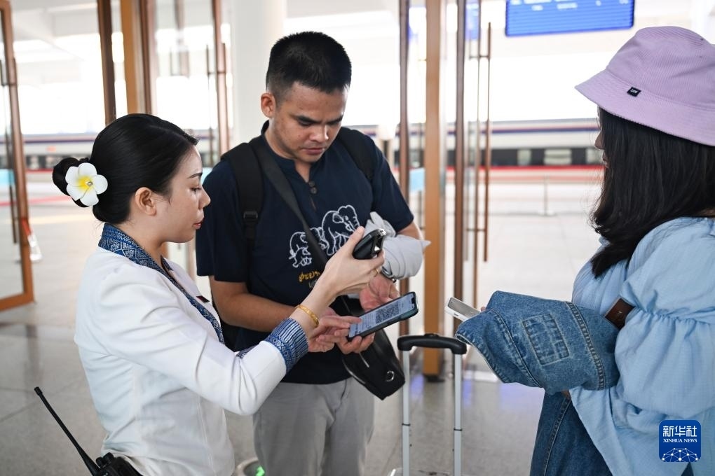 10月12日，在老撾萬象中老鐵路萬象站，工作人員檢驗乘客車票。新華社記者 程一恒 攝