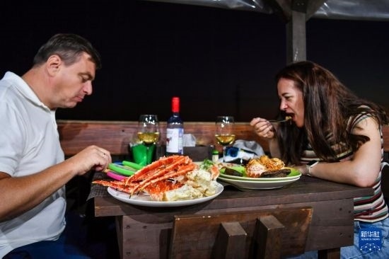 9月2日，食客們在俄羅斯符拉迪沃斯托克的一家餐館品嘗帝王蟹。新華社記者 曹陽 攝