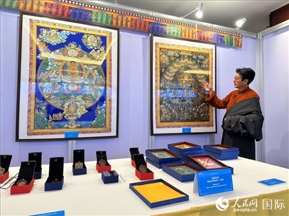 熱貢藝術(shù)國家級代表性傳承人夏吾角向嘉賓介紹作品。人民網(wǎng)記者 簡承淵攝