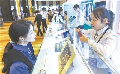 在北京麗澤商務(wù)區(qū)，工作人員（右一）介紹數(shù)字人民幣SIM卡硬錢包。新京報記者 陶冉攝