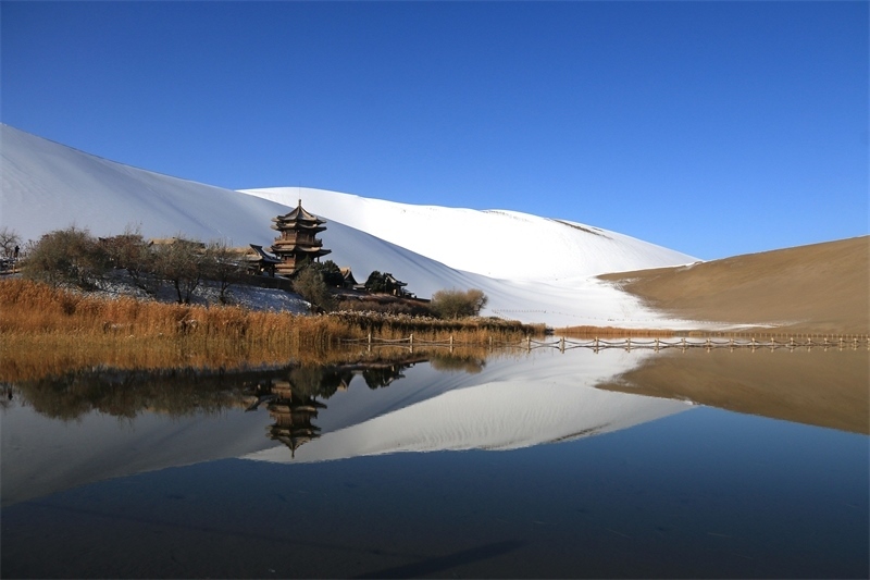 鳴沙山月牙泉景區(qū)雪景。敦煌市委宣傳部供圖，張曉亮攝