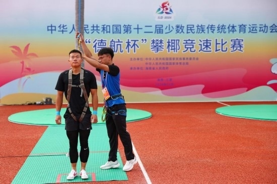 11月23日，工作人員為上海隊選手付樂樂（左）系安全繩。新華社記者 楊植森 攝