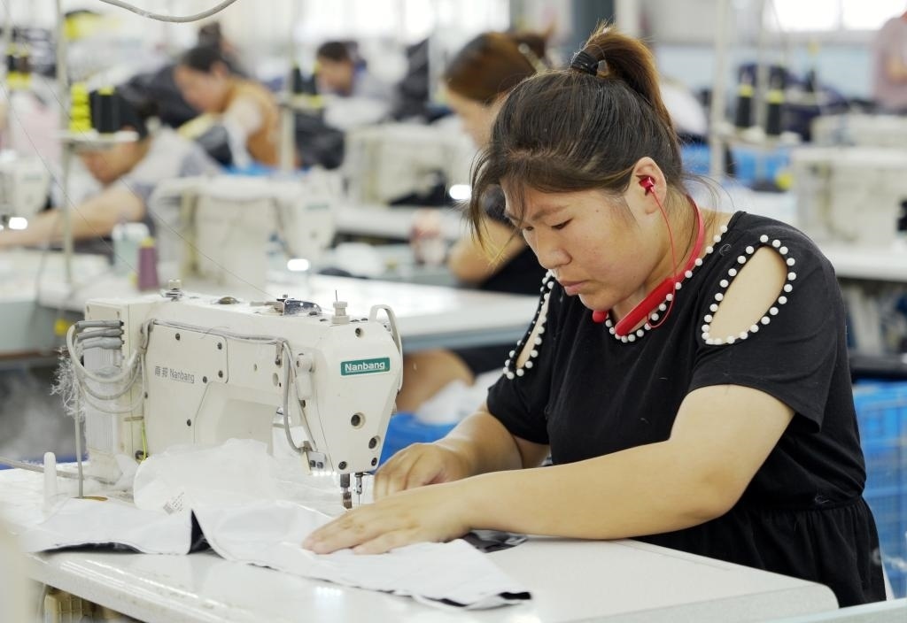 5月20日，村民在李寨村服裝加工廠內忙碌。河南省周口市沈丘縣馮營鎮(zhèn)李寨村地處豫東平原。近年來，乘著脫貧攻堅與鄉(xiāng)村振興政策的東風，李寨村積極探索產業(yè)發(fā)展模式，通過“龍頭企業(yè)+村集體經(jīng)濟+農戶”的方式，逐漸發(fā)展形成肉牛養(yǎng)殖、設施農業(yè)、服裝加工、康養(yǎng)民宿等產業(yè)，以產業(yè)振興助力鄉(xiāng)村振興。新華社記者 李嘉南 攝