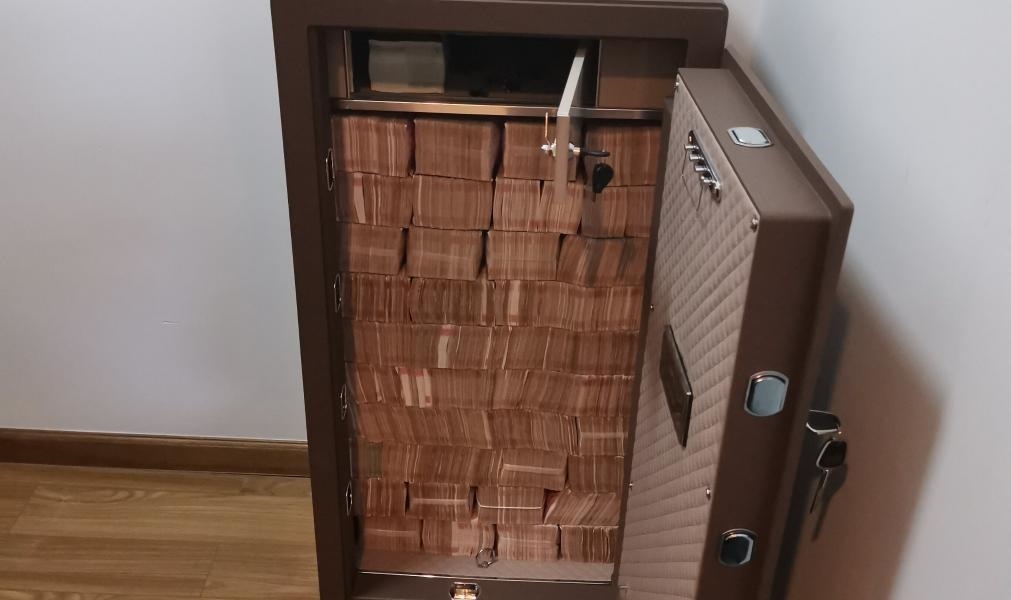 圖為警方查獲藏匿于保險柜中的現(xiàn)金。（警方供圖）